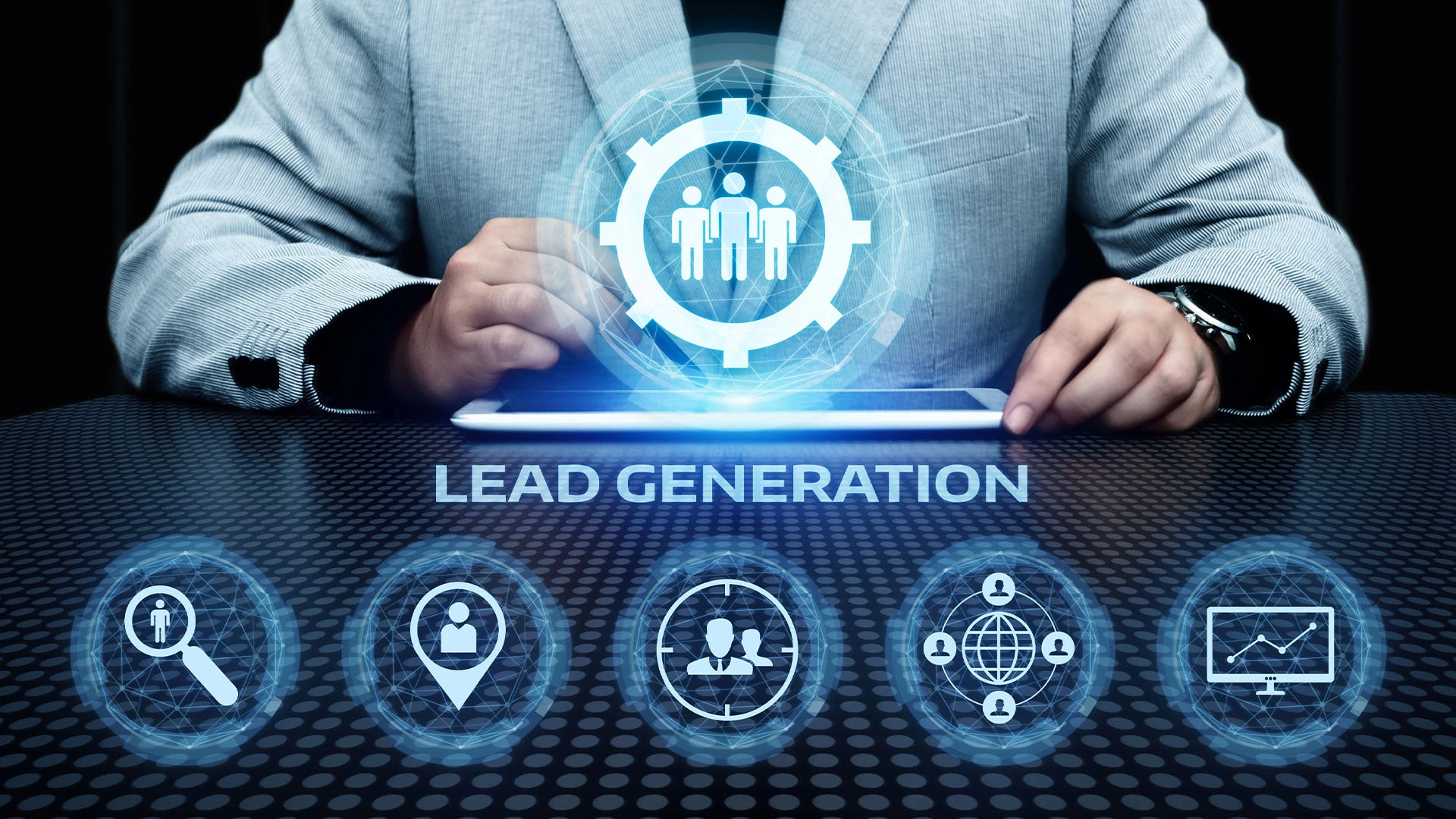 A man sits at a desk with a tablet. Illuminated icons representing lead generation are located above and below the tablet.